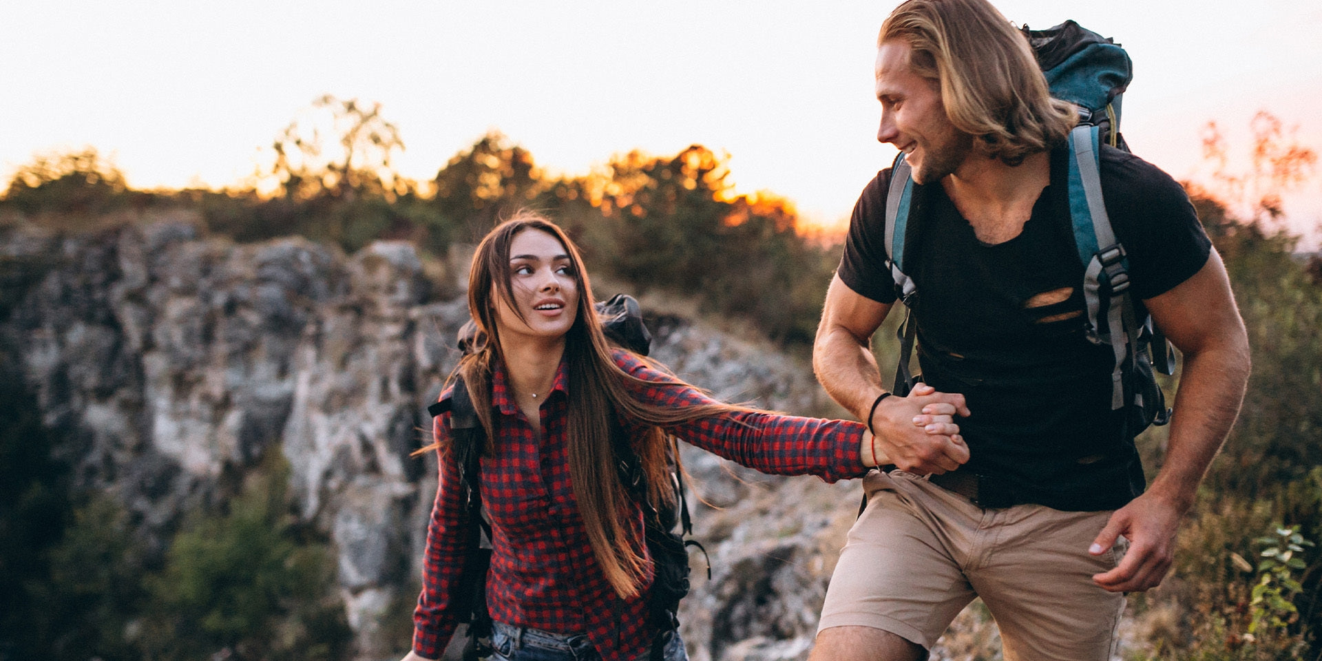 man holding woman's hand on outdoor hike