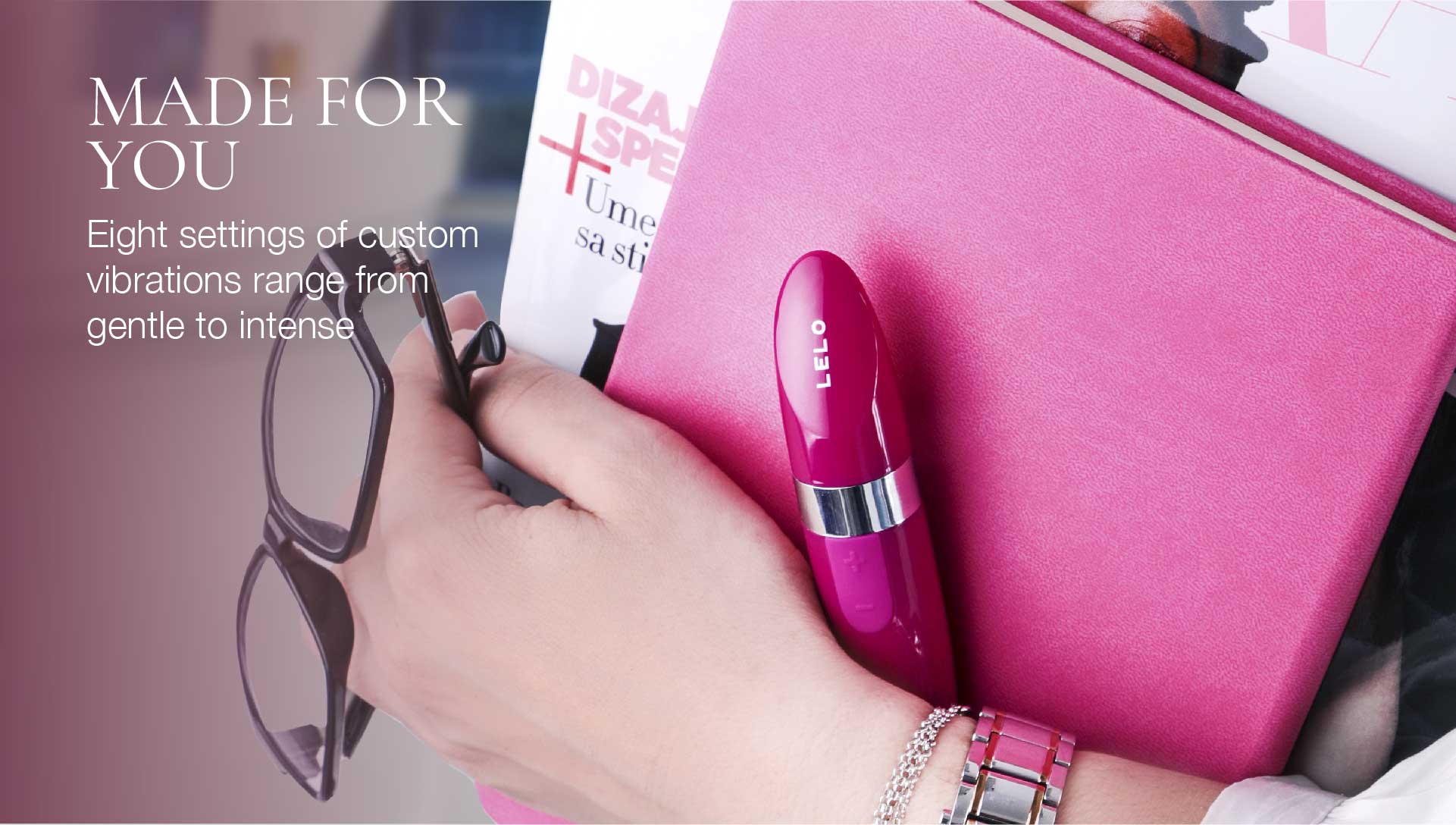 Hand holding a pink electronic device with text about customizable vibrations.