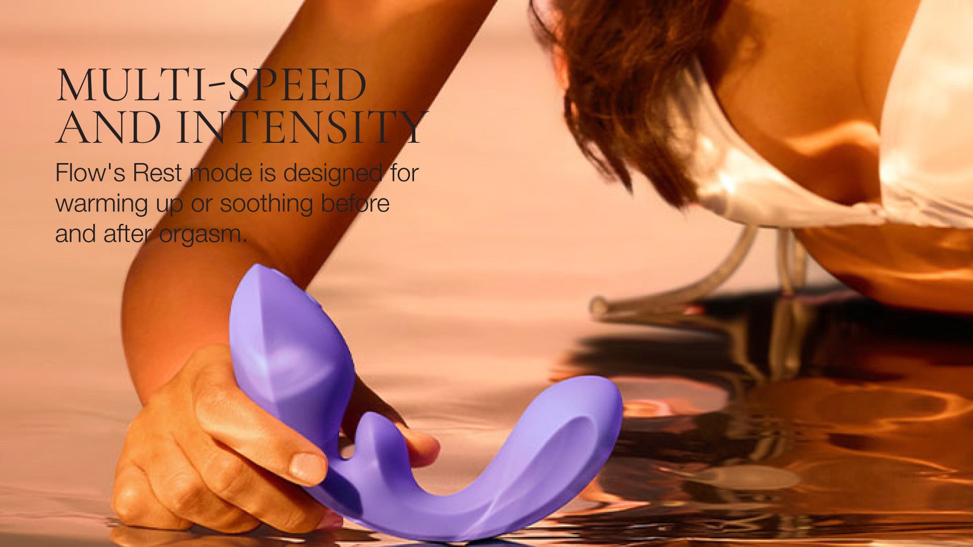 Purple vibrator held by a person with water in the background