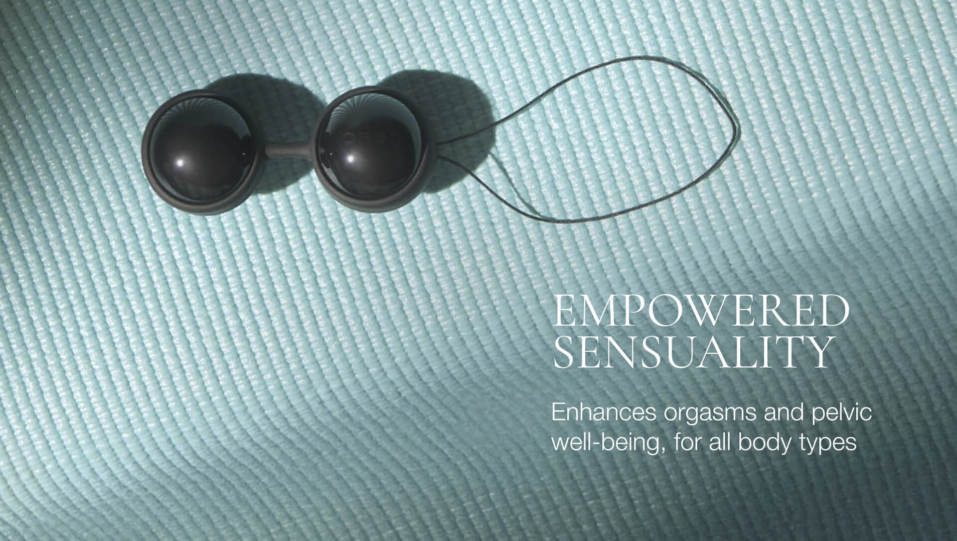 Black spherical objects on a textured light blue surface with text about empowered sensuality.