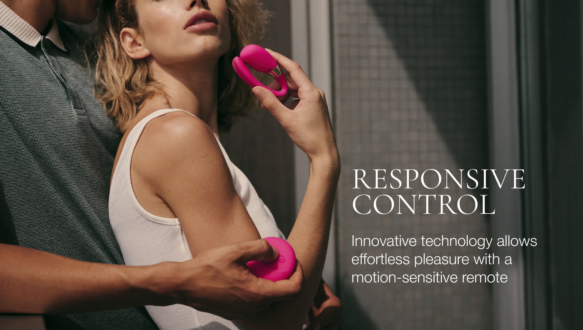 Person holding a pink remote control with text about responsive control technology.