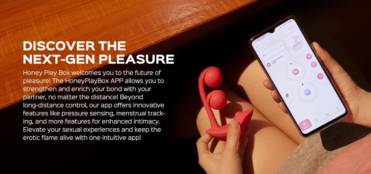 Person using a smartphone with the Honey Play Box app and a red device on a wooden surface.