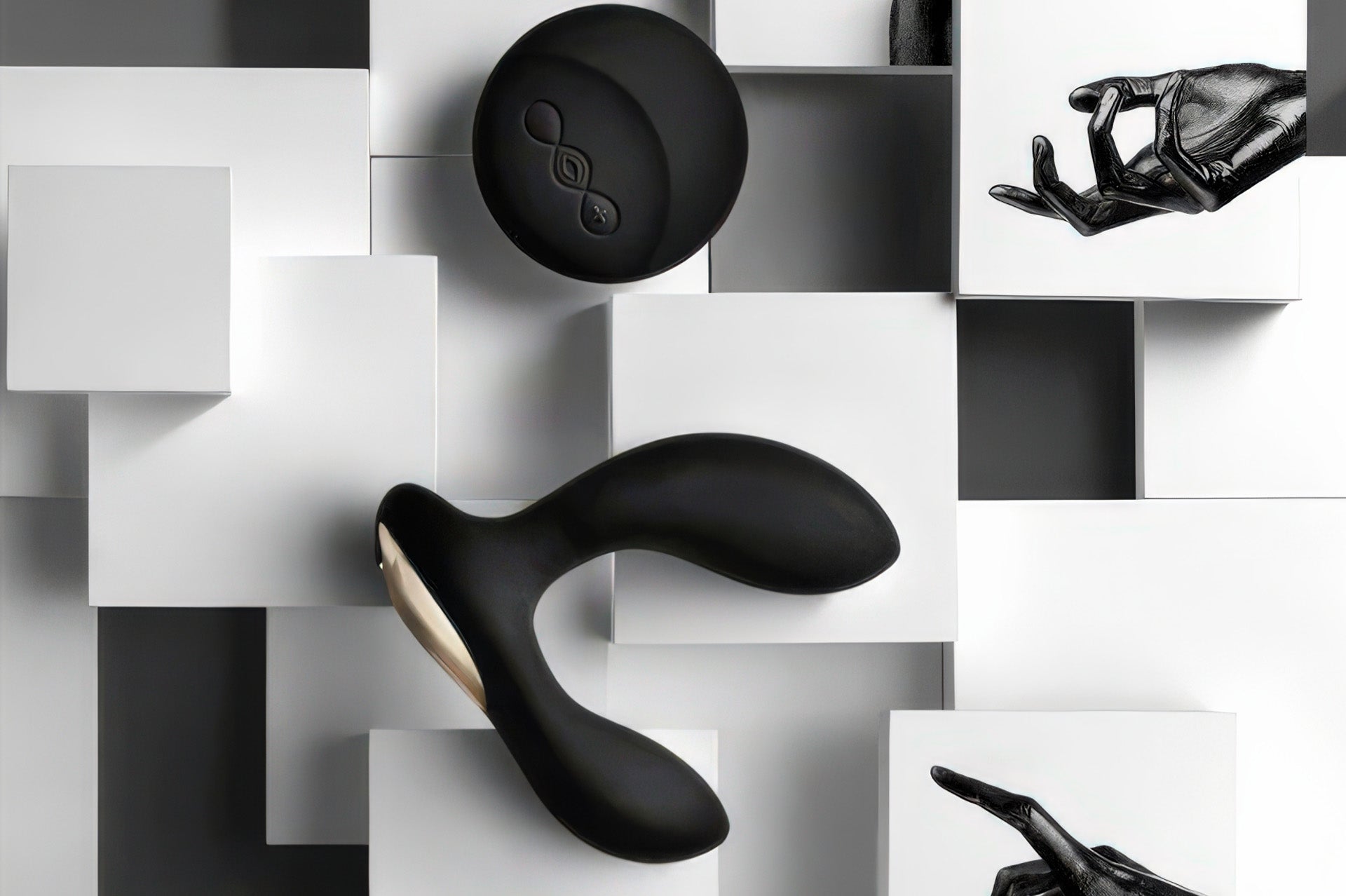 LELO Hugo black prostate massager and remote control arranged on a geometric black-and-white block surface.