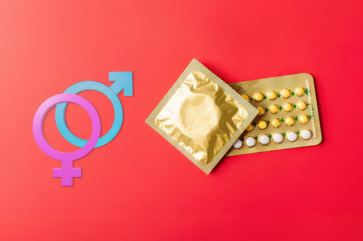 Male and female gender symbols beside a foil-wrapped condom and a blister pack of pills on a red background.