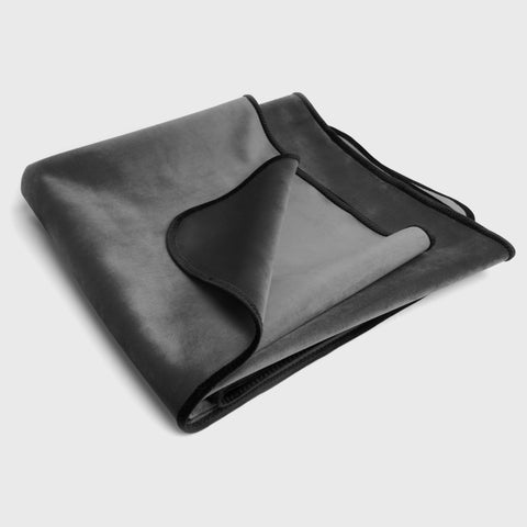 Folded black blanket on a white background