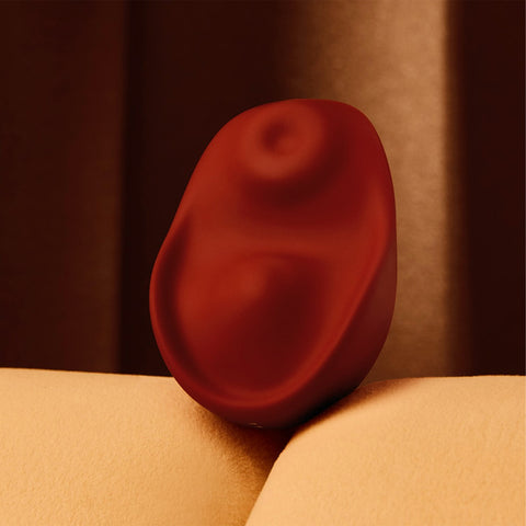 Kiss vulva tapping and heated vibrator by Osuga in Chocolate color on a couch