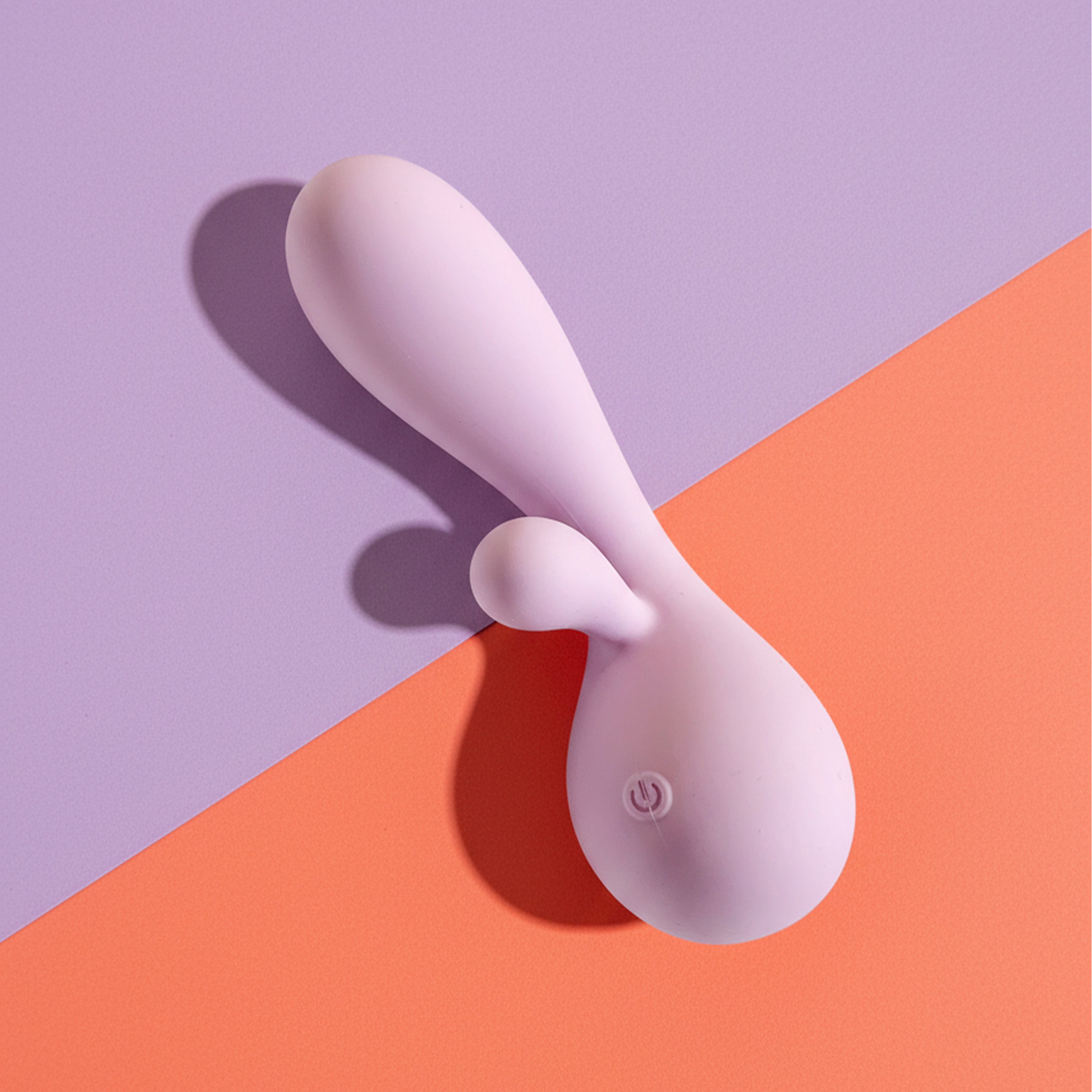 Purple silicone rabbit vibrator on a two-tone purple and orange background