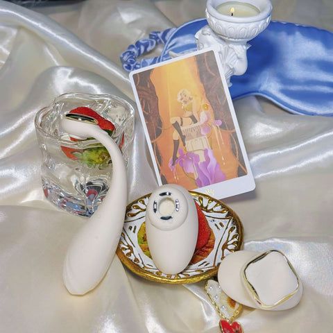 Decorative setting with collectible card, candle, and other items on a satin surface