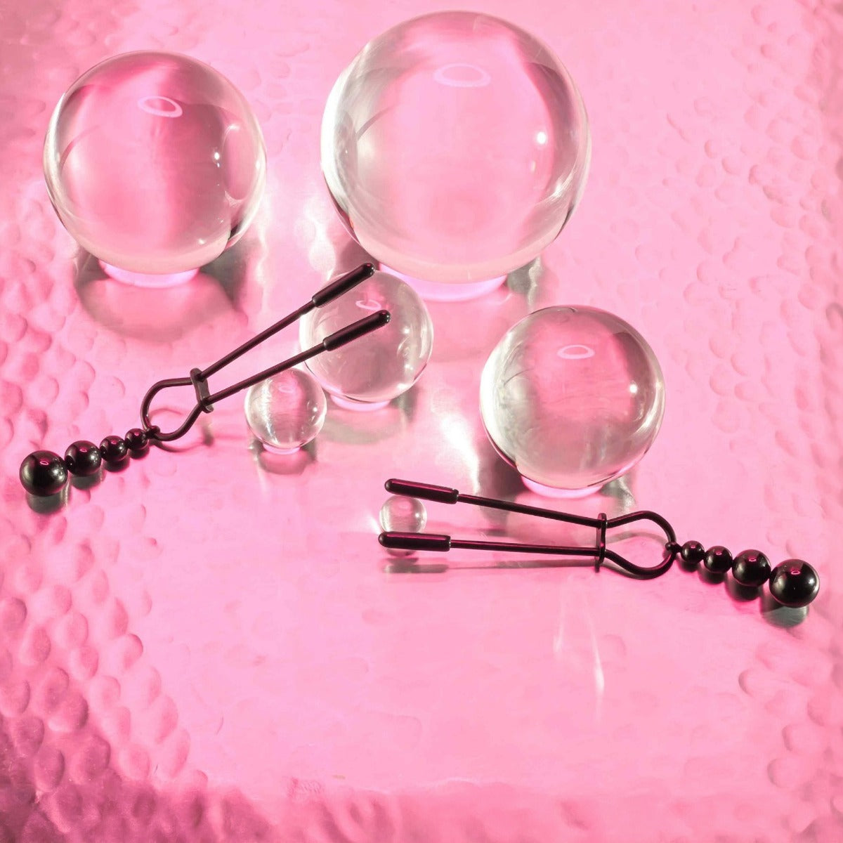Selopa Beaded Nipple Clamps in Black on pink background with bubbles