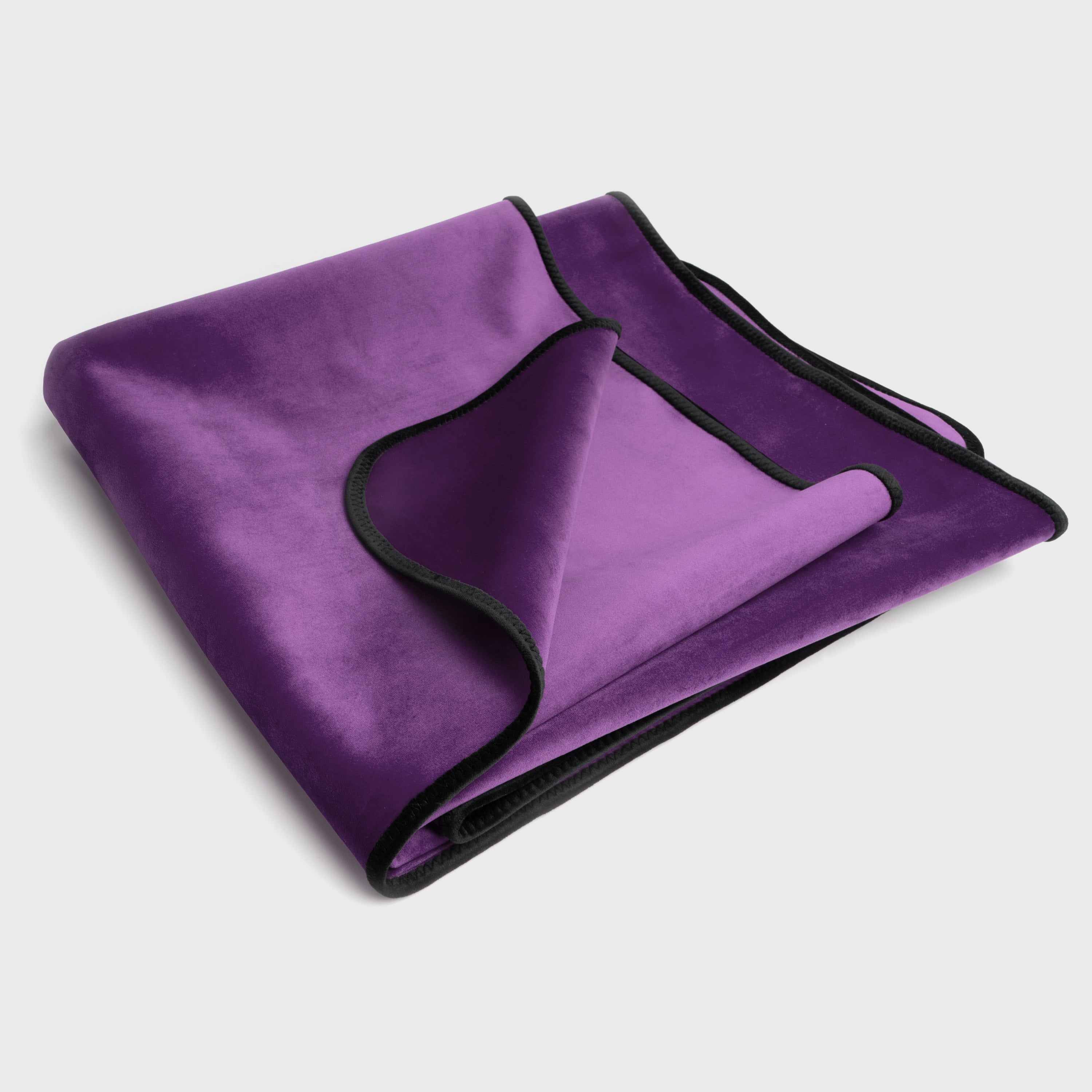 Purple blanket with black edges on a light gray background