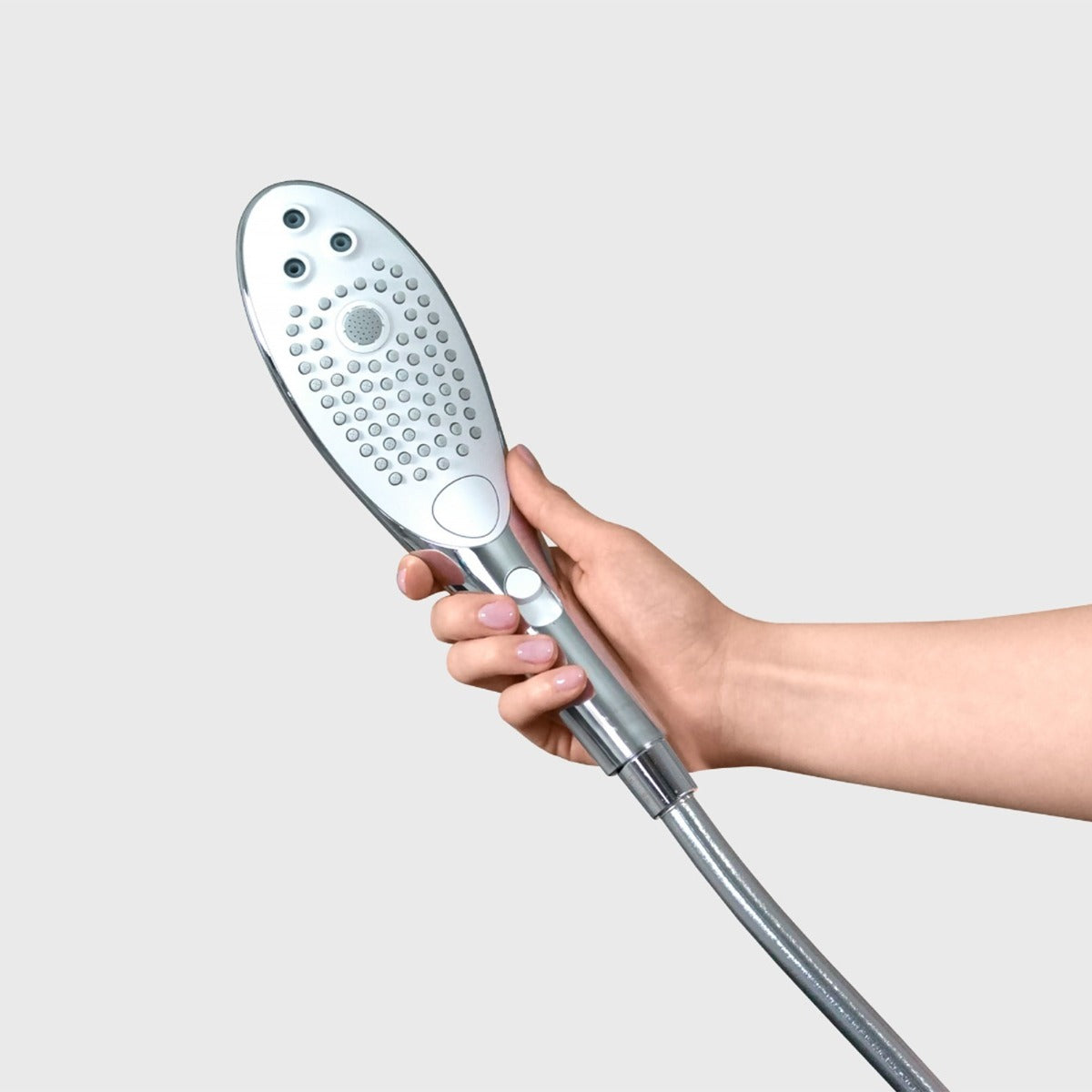 Hand holding a shower head against a light gray background
