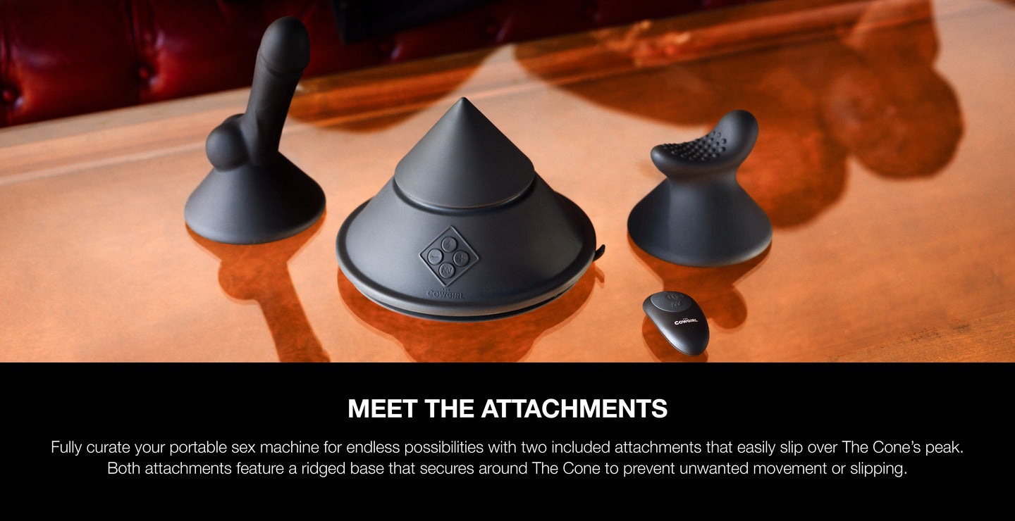 Three black attachments for a portable sex machine on a wooden surface.