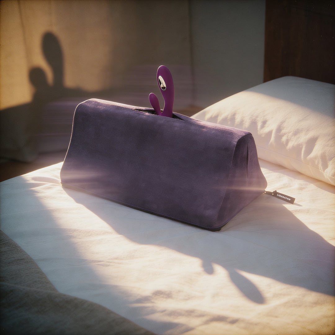 Purple toy mount with a pink toy on a bed