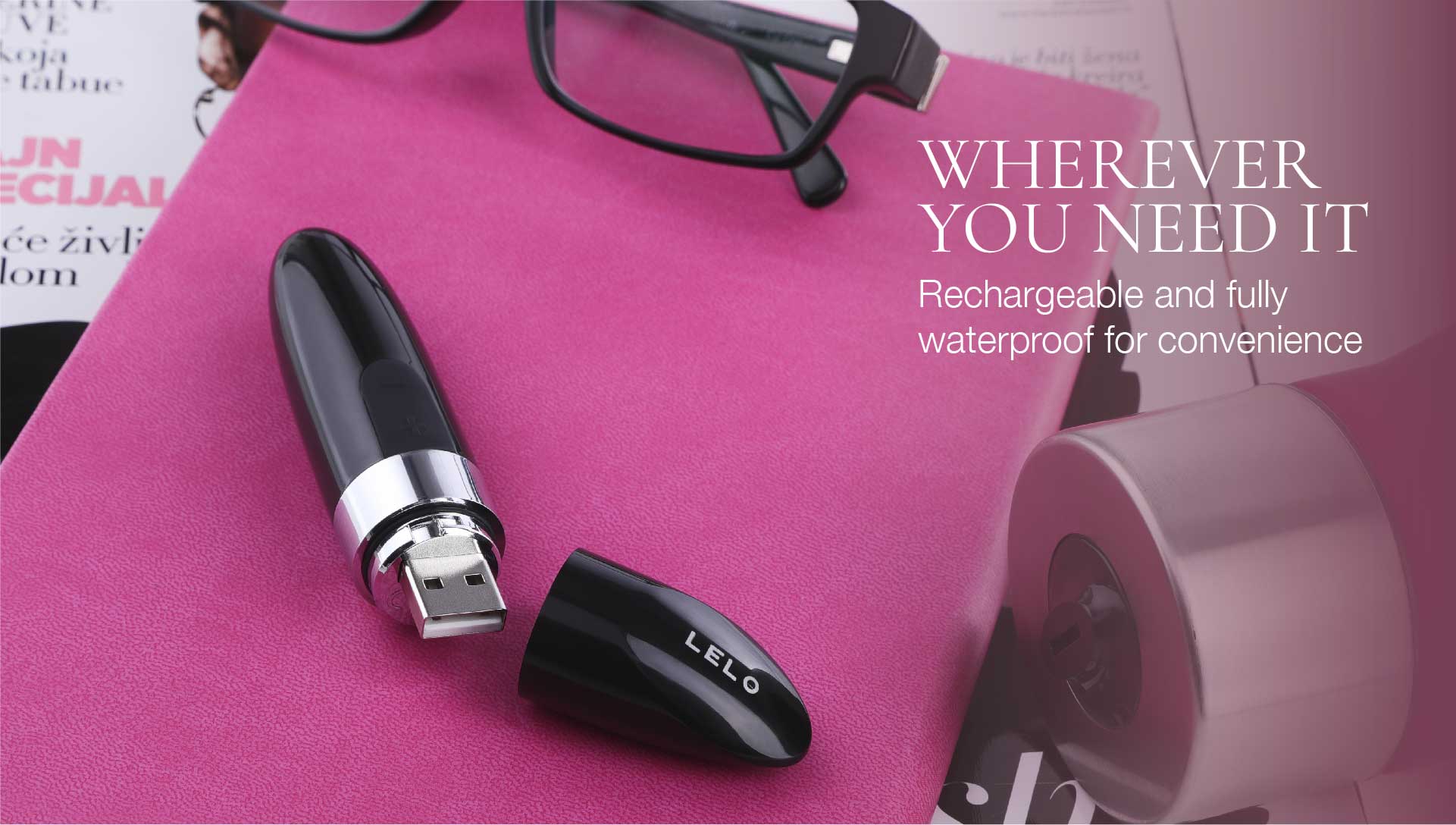 Black and silver electronic device on a pink surface with text about rechargeability and waterproofness.