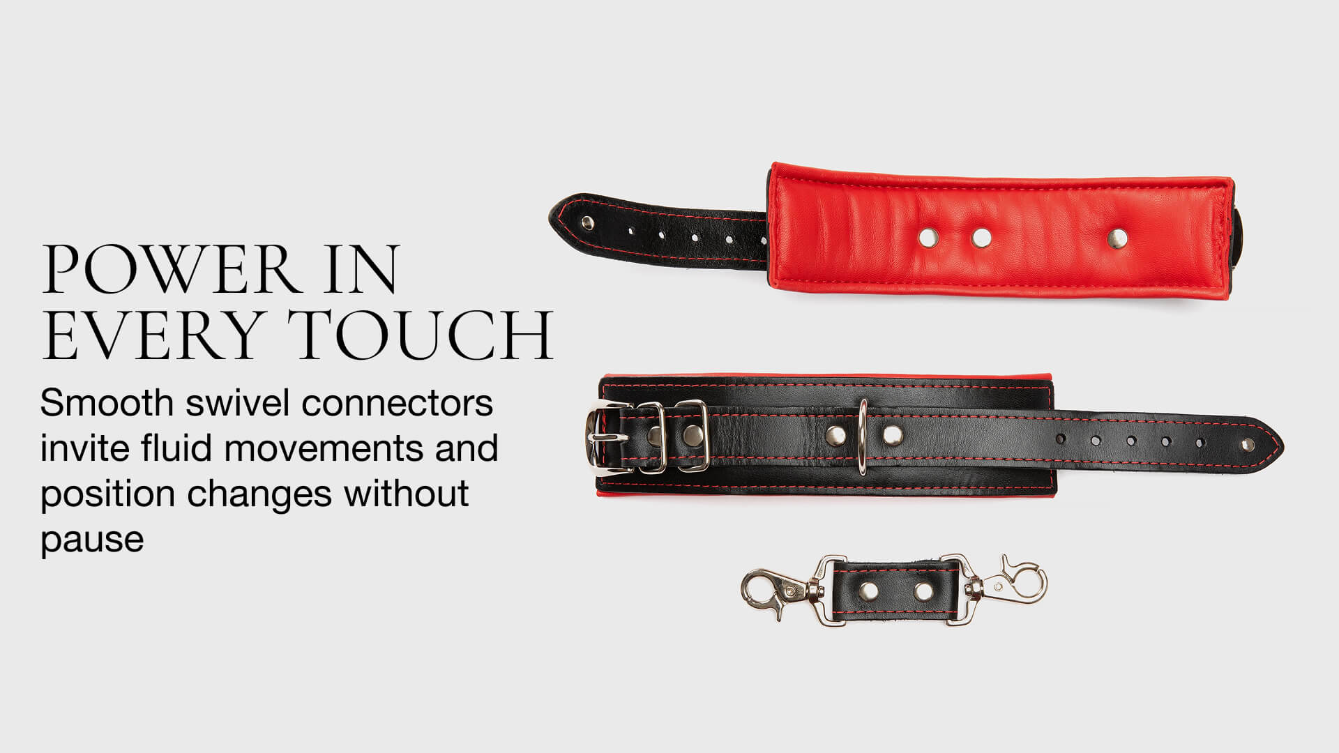 Red and black leather straps with swivel connectors on a light gray background