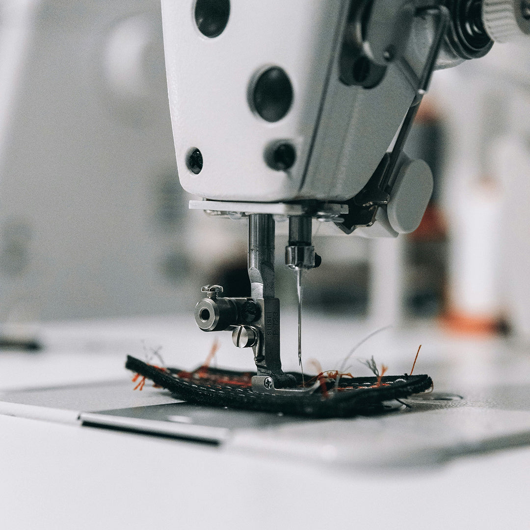 Close-up of a sewing machine needle in action with a blurred background