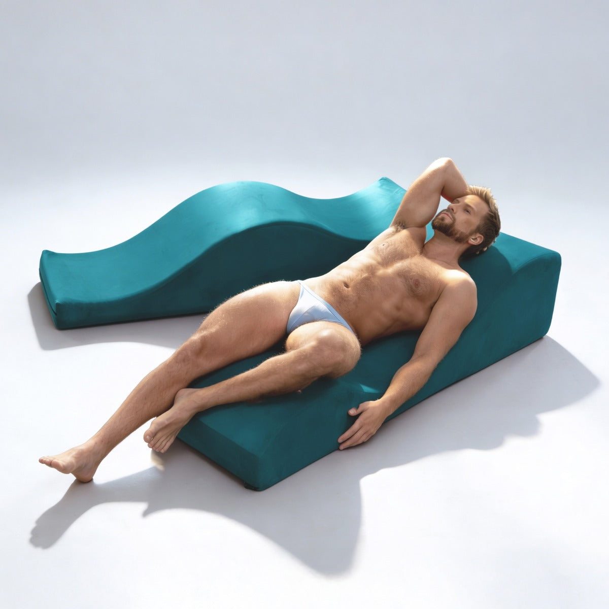 Man leaning back on Equus Wave in blue in white room