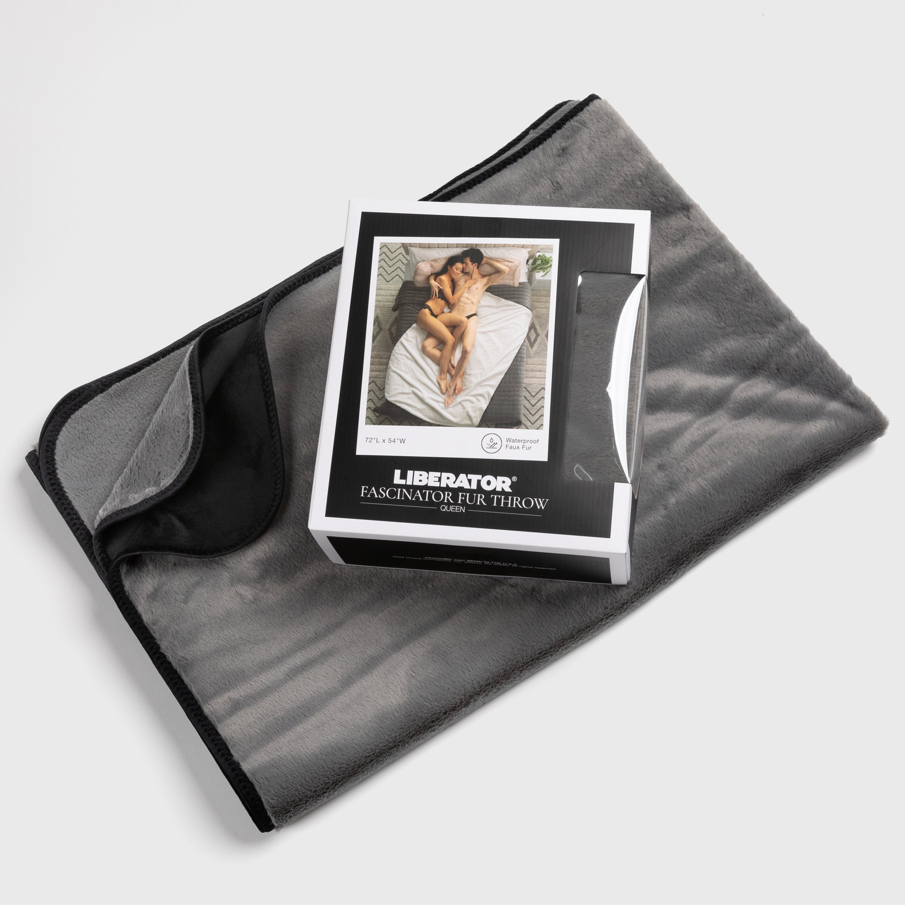 Gray fleece blanket with a box of 'Liberator' product on top, on a light gray background