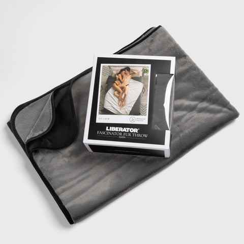 Gray fleece blanket with a box of 'Liberator' product on top, on a light gray background