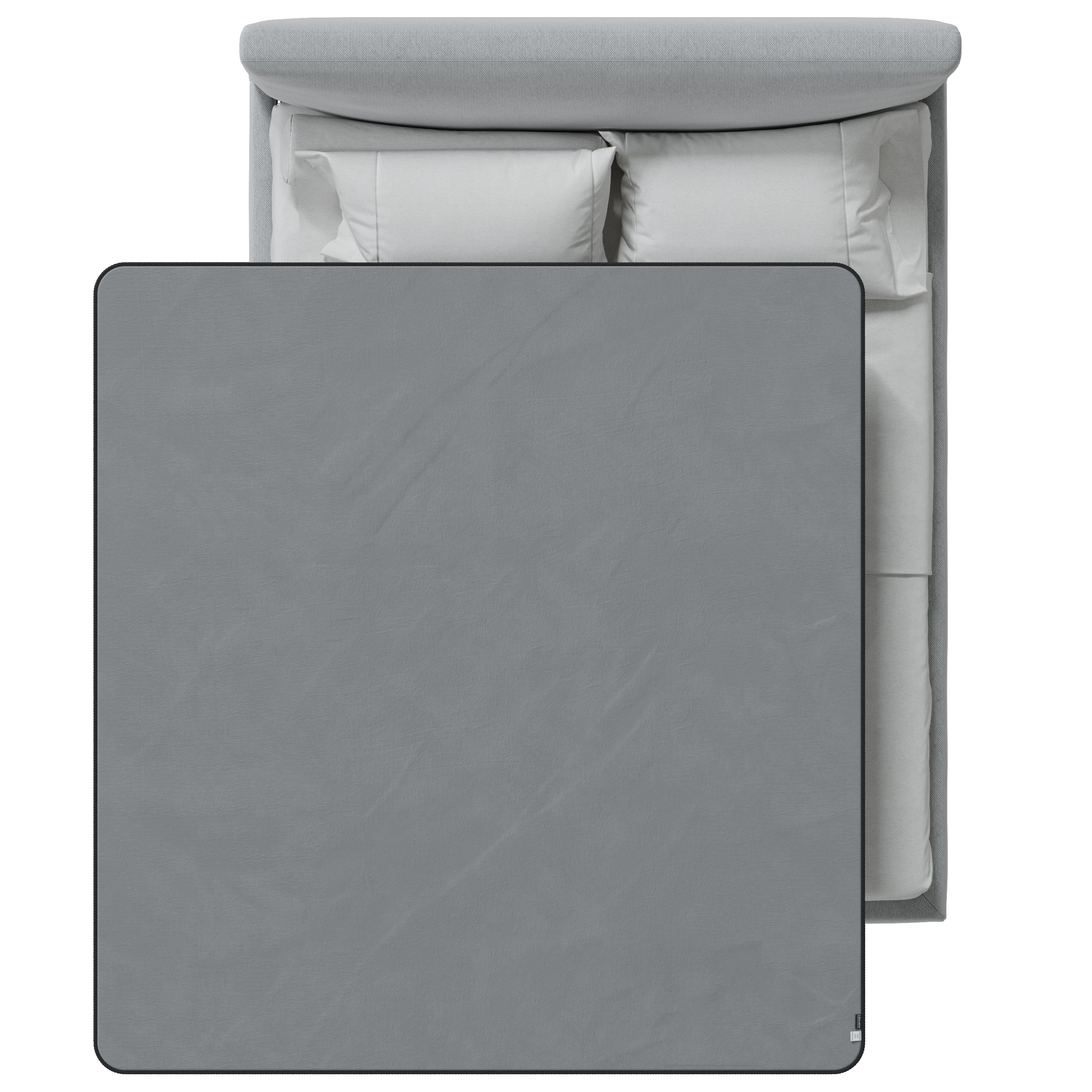 Gray blanket on a bed with white bedding