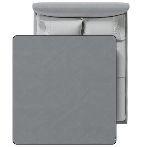 Gray blanket on a bed with white bedding