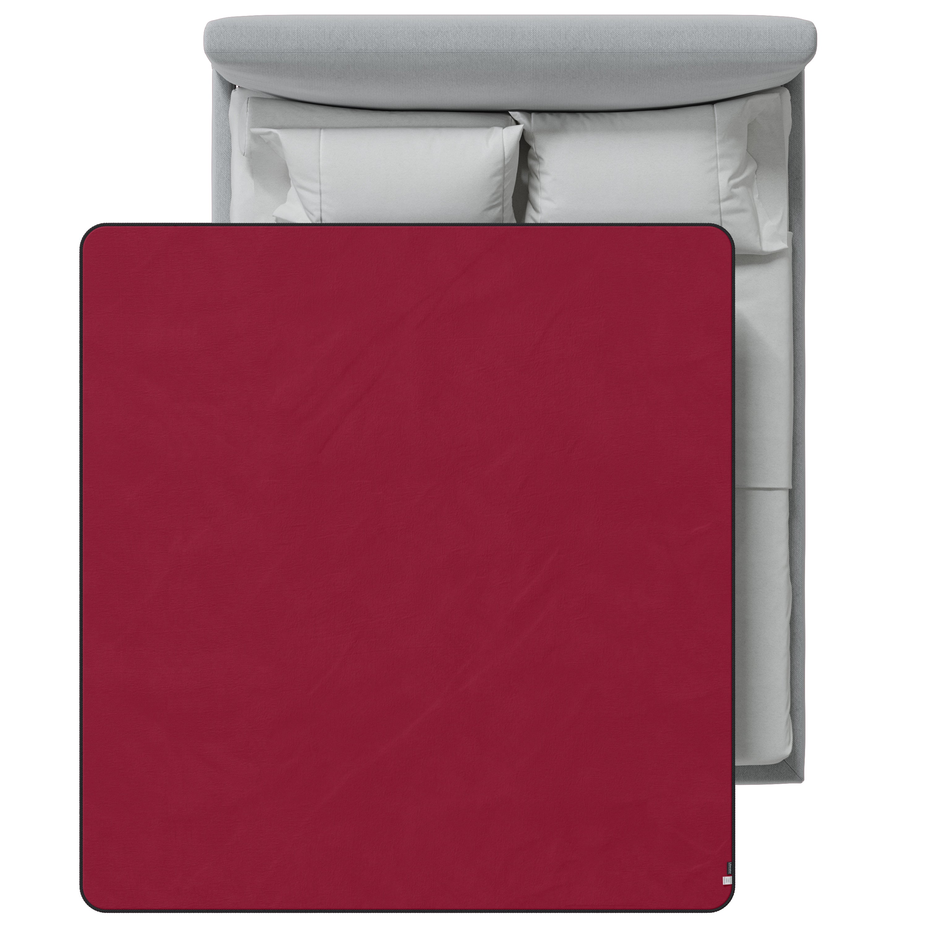 Red blanket on a bed with gray headboard and white pillows