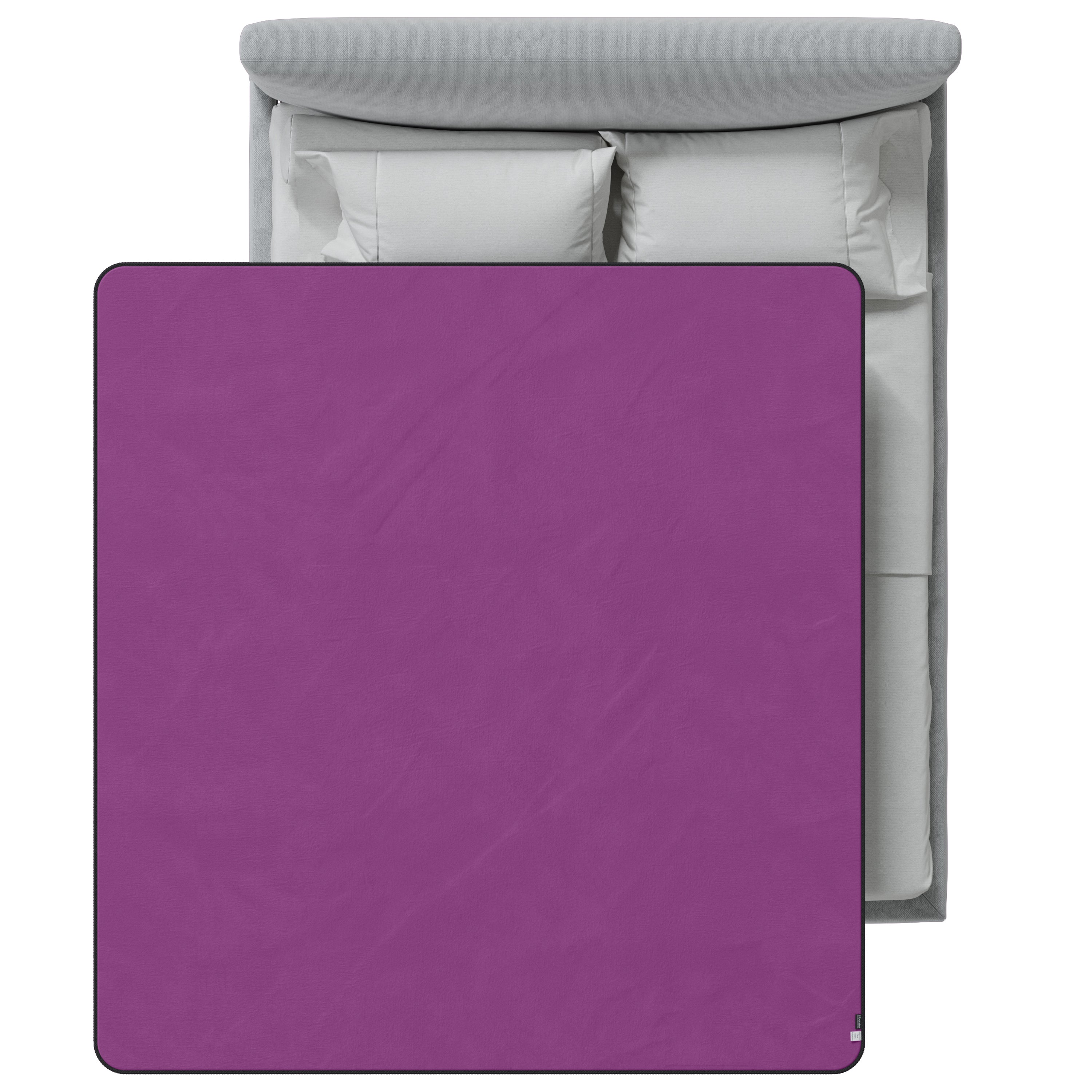 Purple blanket on a bed with gray headboard and white pillows.