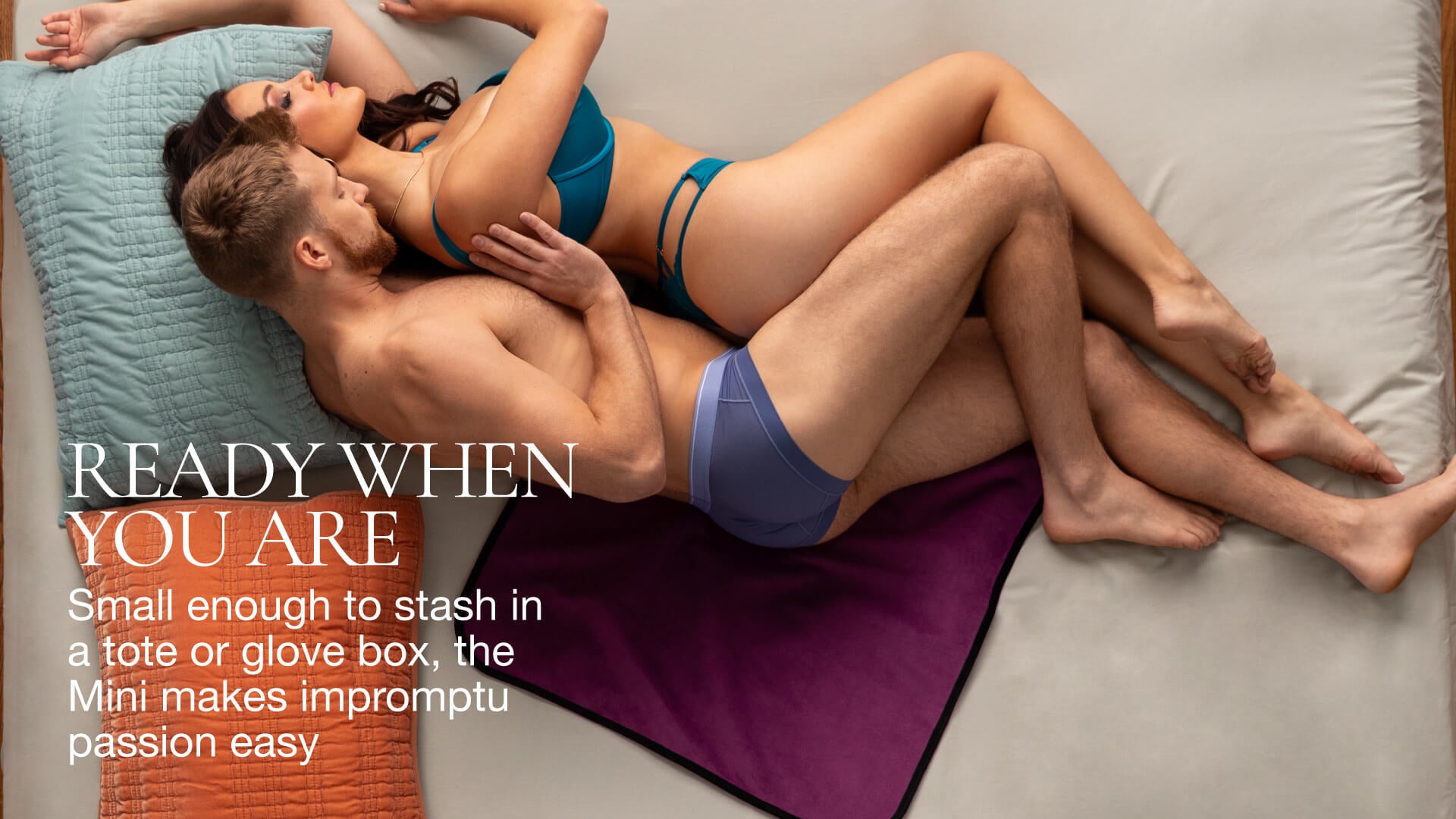 Two people in underwear lying on a bed with text about their mini throw.