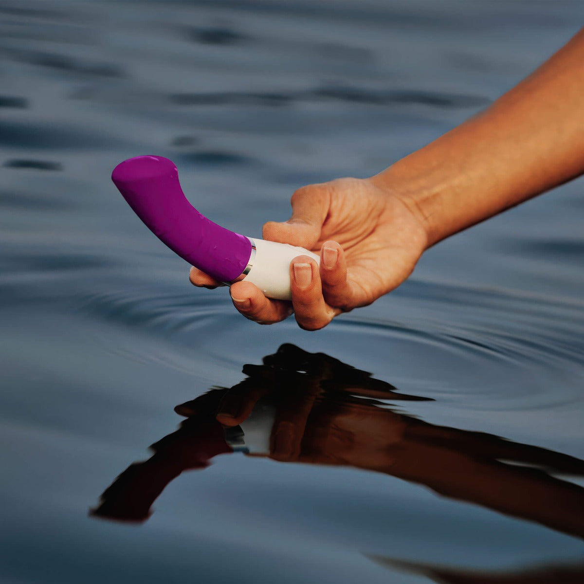 LELO Gigi 3 in Purple being held by a woman, close-up over body of water.

