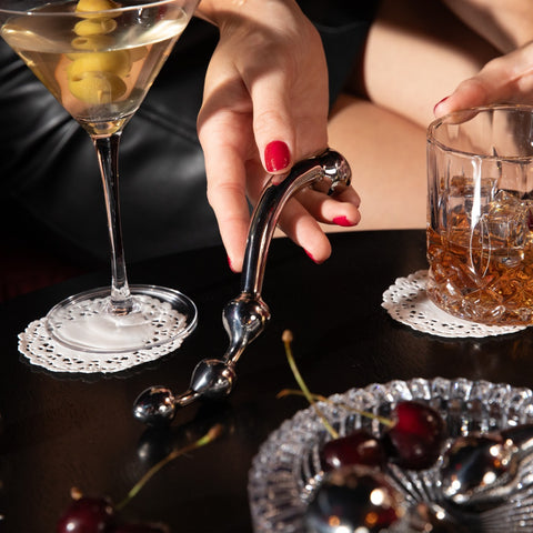 Hand holding Corda wand next to drink glasses on table