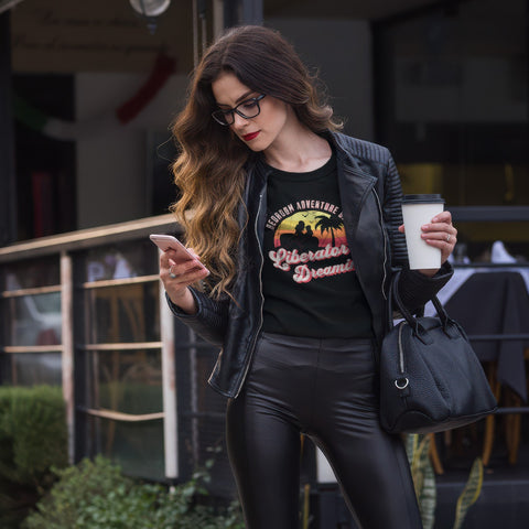 Business woman holding a cup of coffee and phone while wearing the Liberator Dreamin' T-shirt