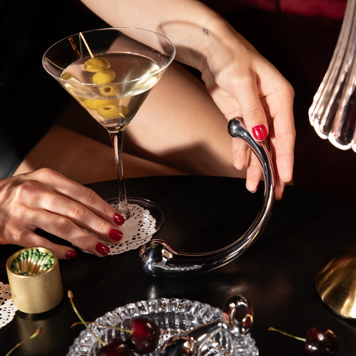 Hand holding Mezzo wand next to martini glass