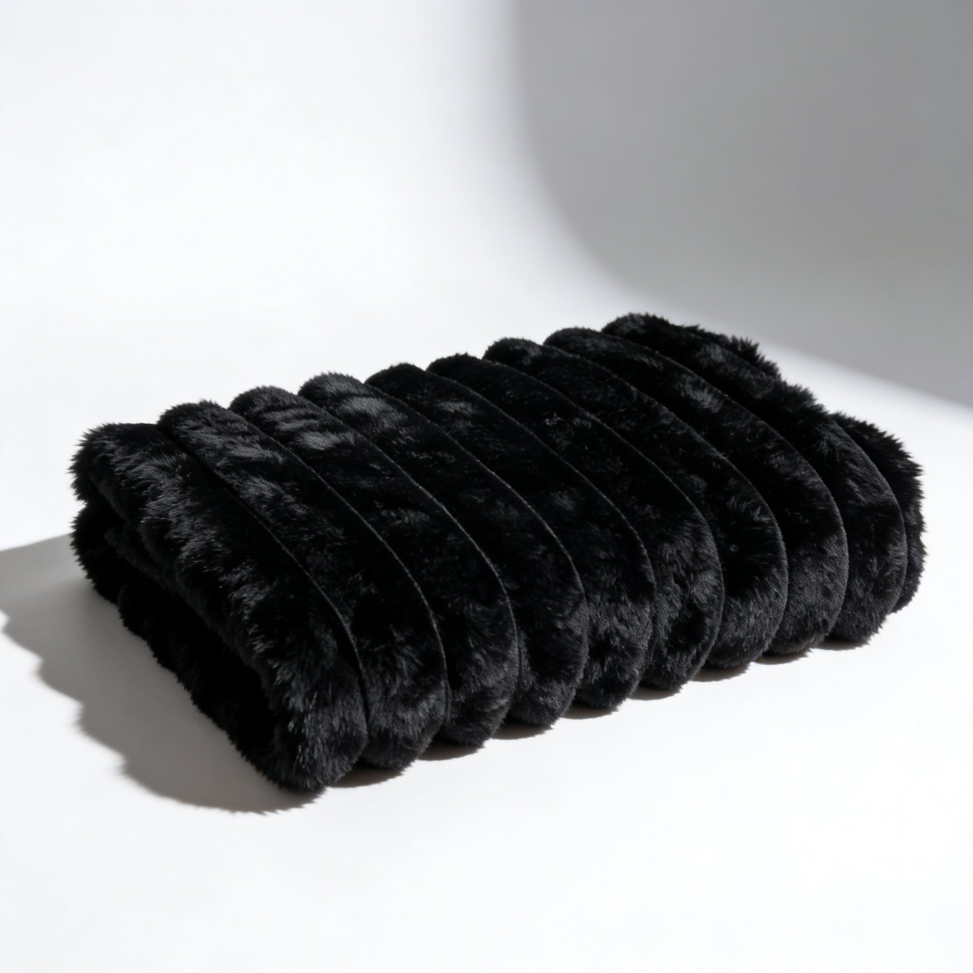 Fascinator Fur Luxe in black folded on white background