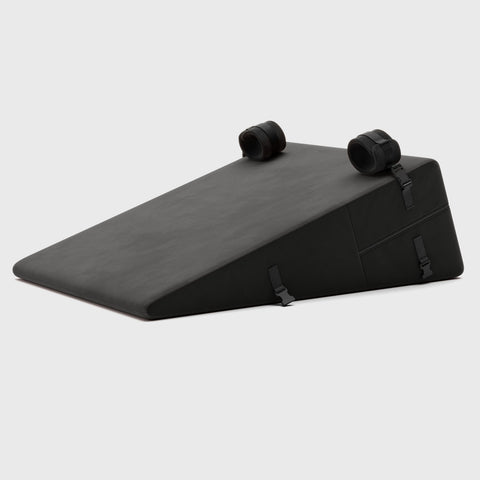 Black wedge-shaped product with two plush cuffs on a white background