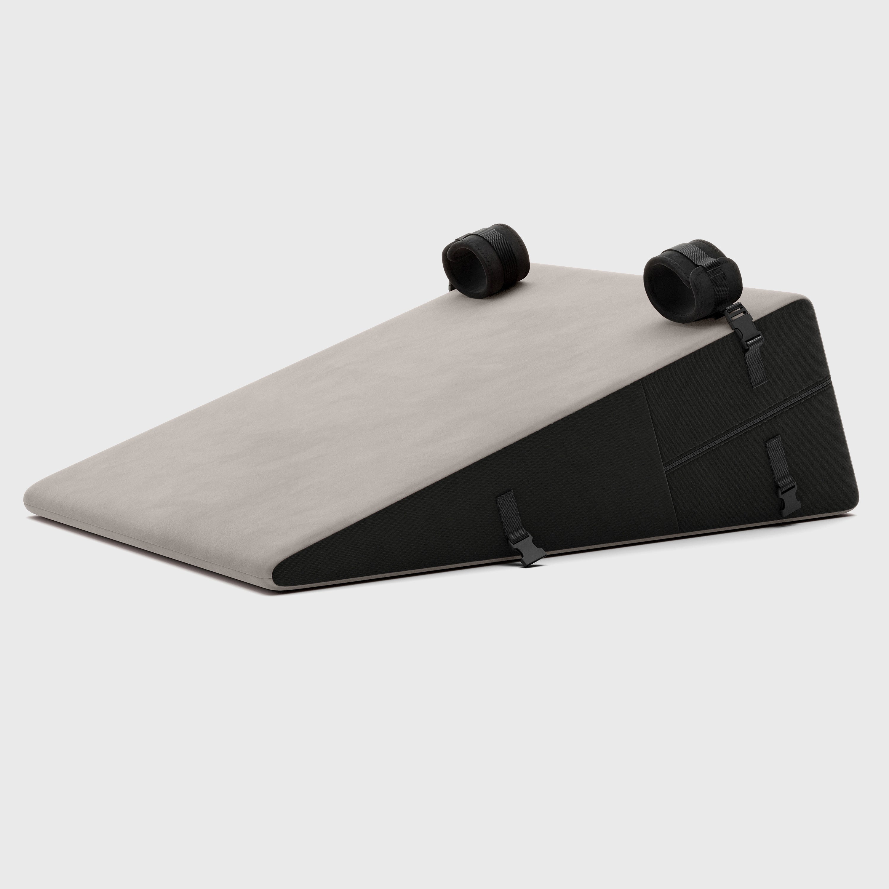 Triangular ramp cushion with black straps on a white background