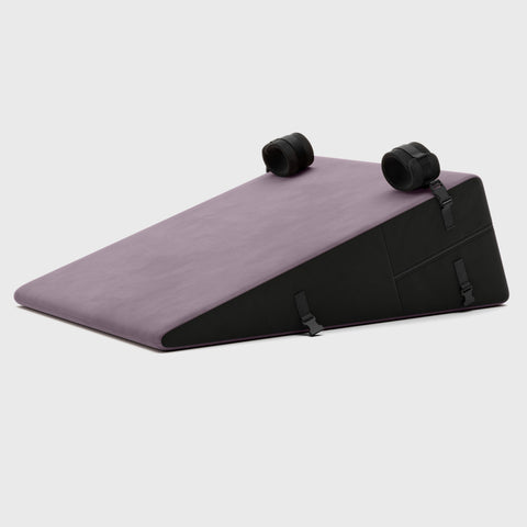 Purple ramp pillow with black straps on a light gray background