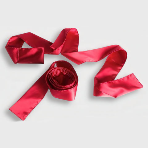 Red satin ribbon on a light gray background