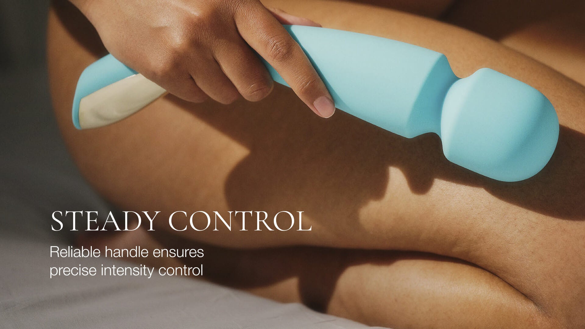 Hand holding a blue handheld device with text about steady control