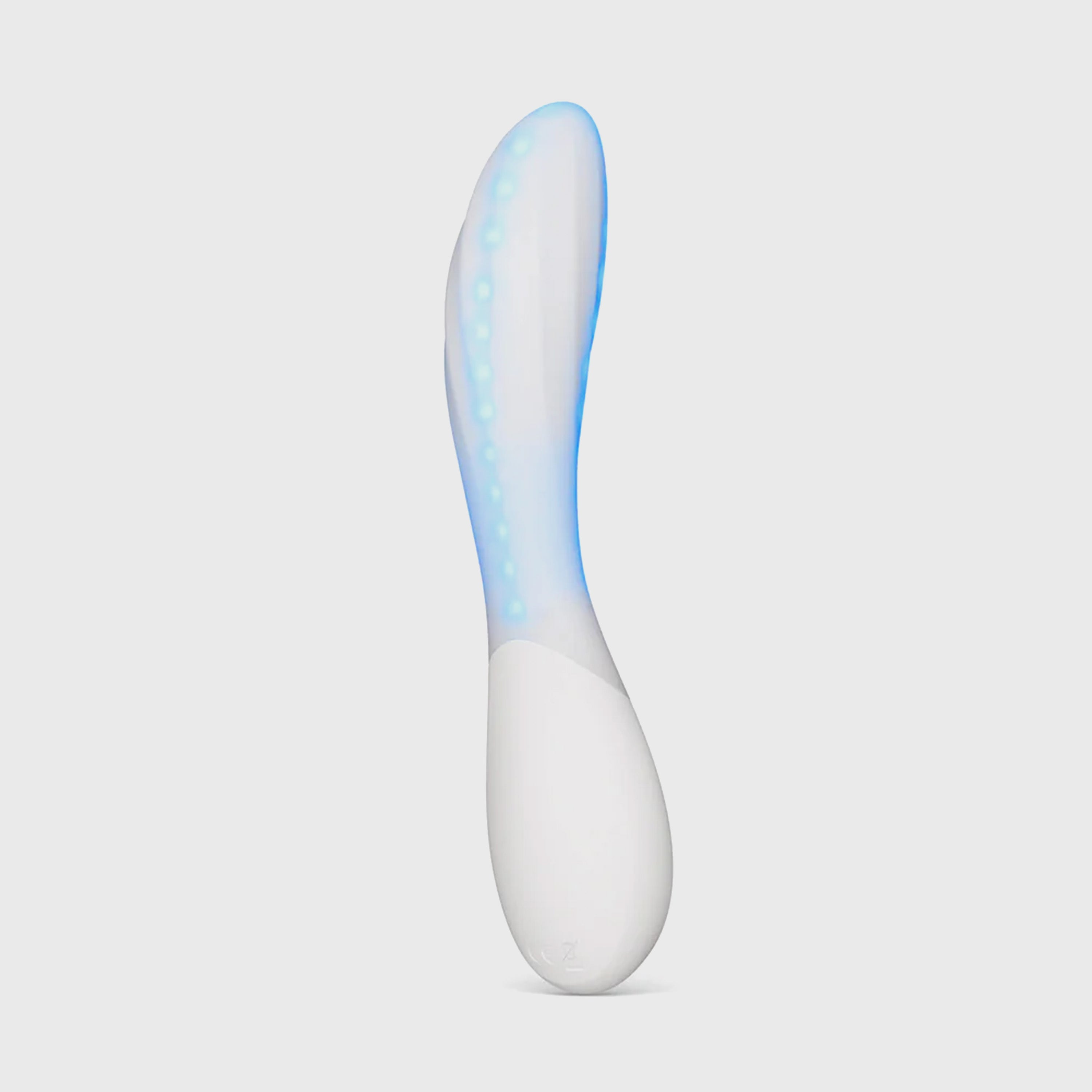 A modern curved personal massager with a white base and a translucent upper section glowing with blue LED light, shown against a solid light gray background.