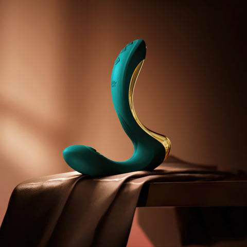 Teal and gold vibrator on a brown surface with a warm background