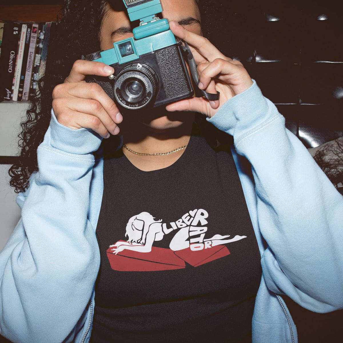 Woman taking a photo while she's wearing her Lady On A Combo Liberator Merch T-Shirt