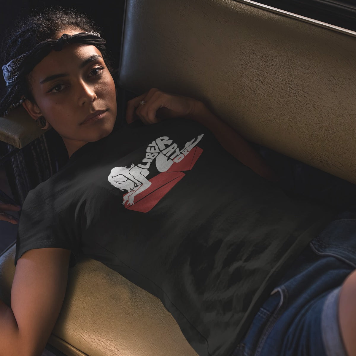 Woman laying back on a sofa wearing Liberator Merch Lady On A Combo womens t-shirt