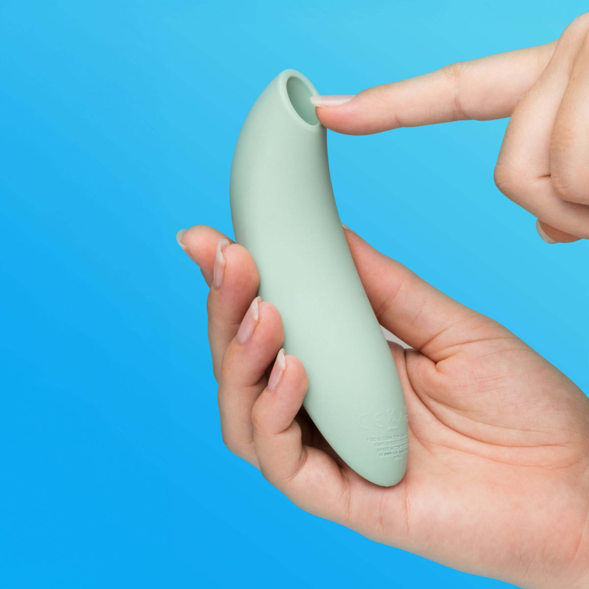 lifestyle of We-Vibe Melt 2 in sage green of woman holding it on colorful blue background