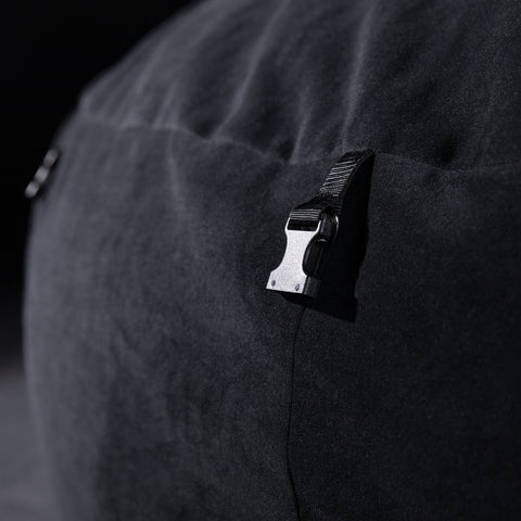 Close-up of a black clip on a dark fabric surface