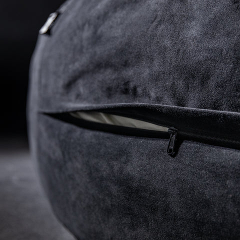 Close-up of a textured gray bag with a zipper on a dark background