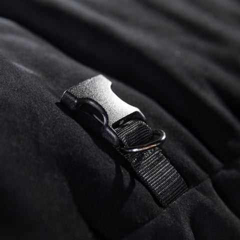 Close-up of a black strap with a plastic buckle on a dark fabric background