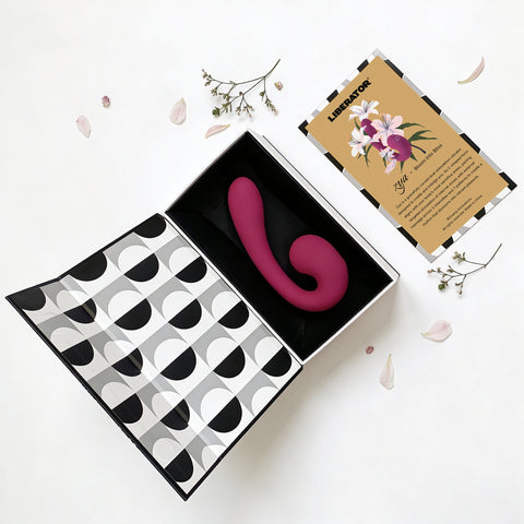 Pink curved vibrator in a decorative box with a patterned interior, on a white background.