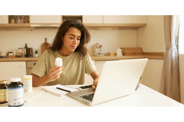Woman sitting at computer with medications