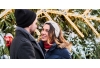 Couple standing together in warm clothing at Christmas tree farm
