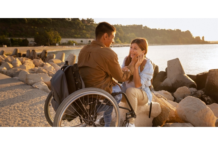 Man in wheelchair holding hands with girlfriend